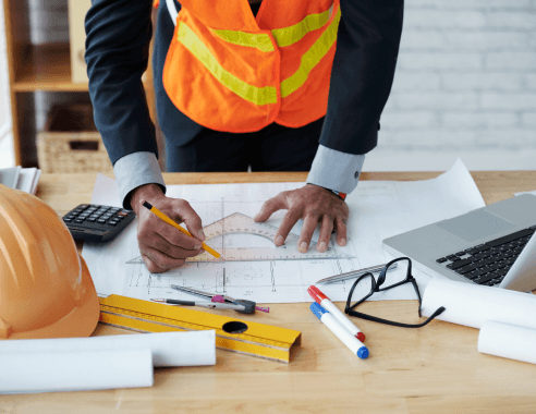 Construction workers reviewing blueprints with hard hat